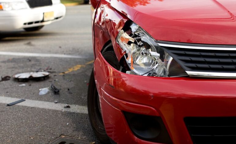 Ein fingierter Verkehrsunfall mit einem roten Auto, dessen rechte Seite und Scheinwerfer kaputt sind