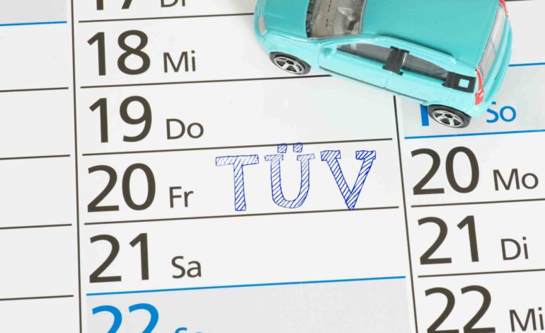 Auf einem Kalender ist ein TÜV Termin notiert. Daneben steht ein türkisfarbenes Spielzeugauto.