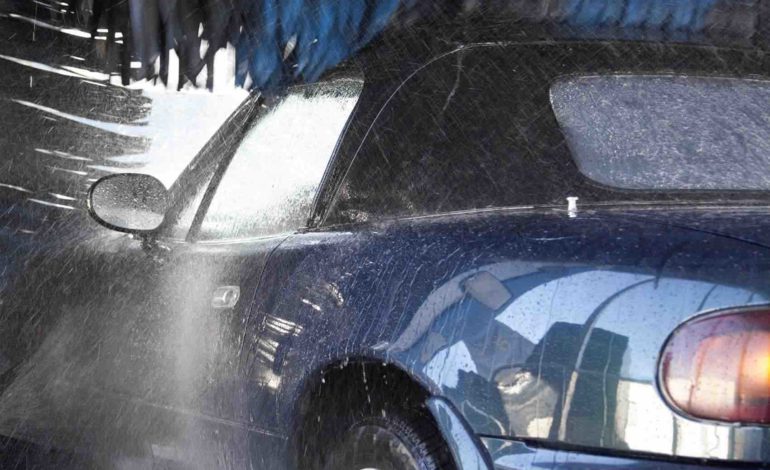 Autowösche im Winter, Blaues Auto in der Waschanlage