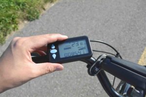 Lenker eines E-Bikes oder Pedelecs. Eine Hand ist im Bild, die das Bord-Display bedient.