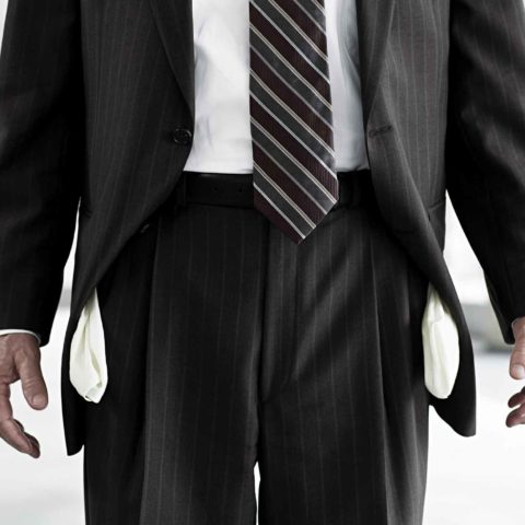Corona Insolvenz: Mann im Anzug mit herausgezogenen Hosentaschen