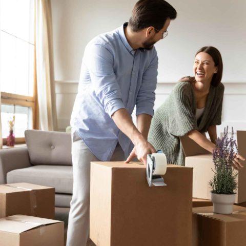 Ein Mann und eine Frau packen Kartons für den Umzug.