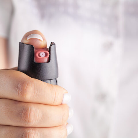 Eine Hand, die mit einem Pfefferspray auf uns zielt, das zu den verbotenen Waffen zählt.