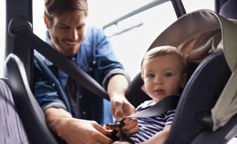 Kleinkind wird im Autositz angegurtet