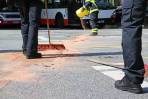 Öl auf der Straße wird durch die Feuerwehr entfernt
