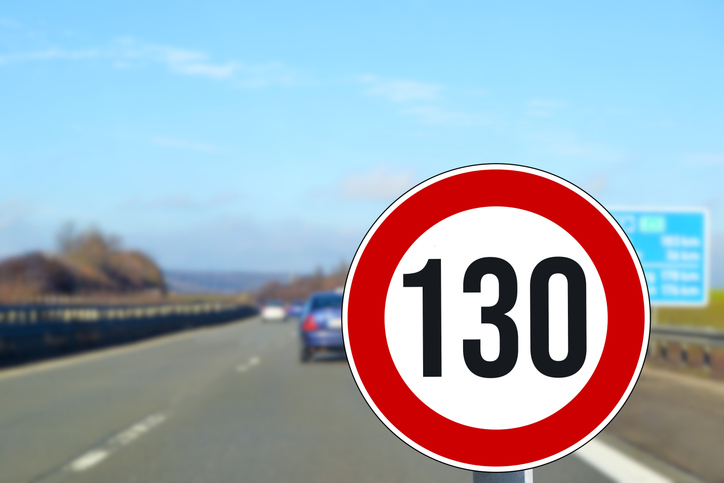 Autobahn im Hintergrund, im Vordergrund Schild mit Richtgeschwindigkeit 130 km/h für Länder ohne Tempolimit