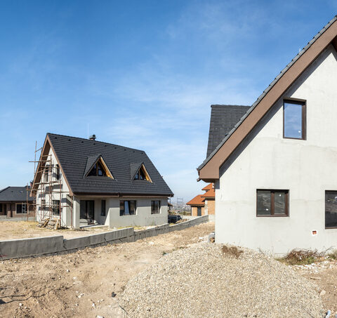 Abstandsfläche beim Hausbau mit zwei neu gebauten Häusern und dazwischen eine Mauer.