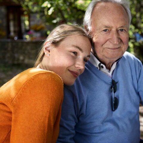 Vorsorgevollmacht erstellen: Mädchen lehnt an Großvaters Schulter.