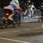 Mehrere Fahrräder mit Fahrradreflektoren auf einer dunklen Straße.