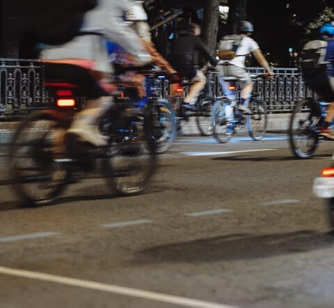 Mehrere Fahrräder mit Fahrradreflektoren auf einer dunklen Straße.