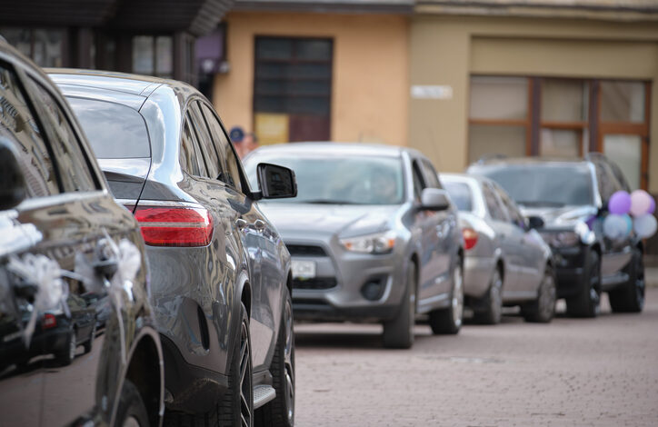 Mehrere Autos am Straßenrand, darunter manche, die falsch herum parken