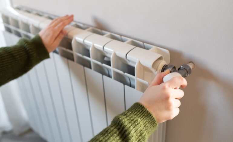 Person prüft Heizkörper bei Heizungsausfall