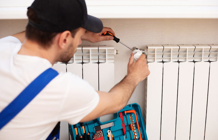 Notdienst behebt einen Heizungsausfall mit Werkzeugkoffer und Schraubenzieher.