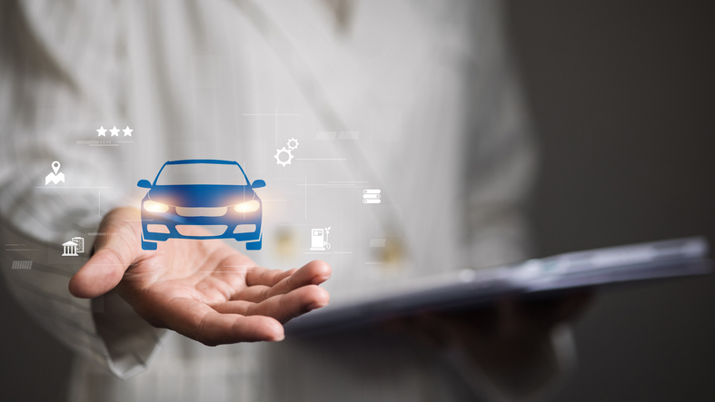 Eine Hand, über der die Grafik eines Autos und anderer Symbole schweben, um die E-Auto-Förderung zu symbolisieren.
