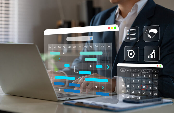 Anzugträger sitzt vor einem Laptop und prüft, ob die Arbeitszeit falsch erfasst ist. Davor schweben Diagramme mit Planungskalendern.