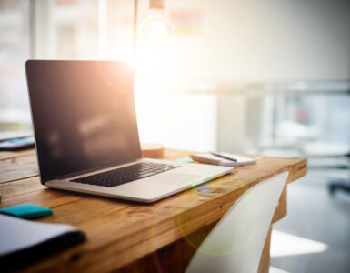 Homeoffice beendet: Ein nicht besetzter Schreibtisch mit einem aufgeklappten, aber ausgeschaltetem Laptop.
