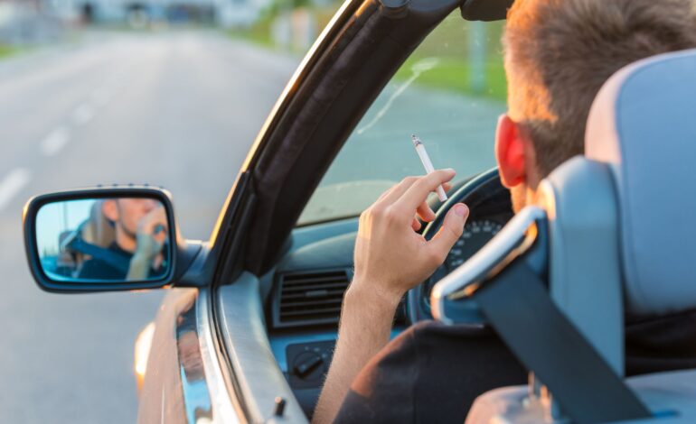Ein Mann raucht Cannabis am Steuer, im Hintergrund ist die Autobahn.