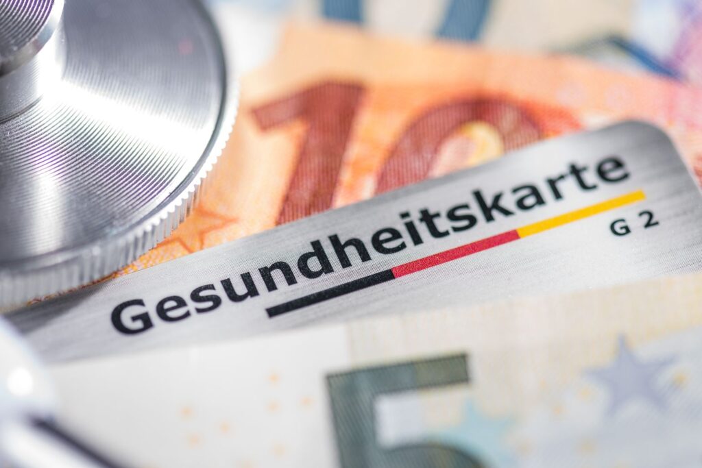 Eine Gesundheitskarte zwischen Geldscheinen symbolisiert Neuerungen im September 2026 bei der Krankenversicherung