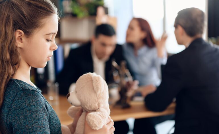 Mädchen mit Teddybär im Vordergrund. Dahinter Mutter und Vater, die mit Anwalt über Unterhalt diskutieren.