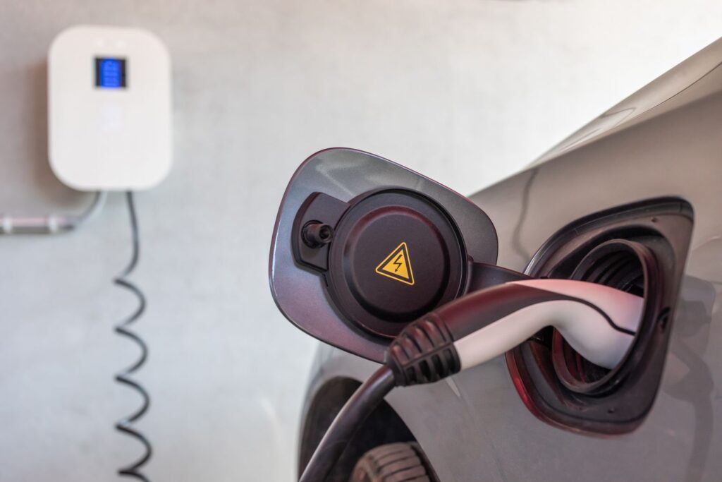 Eine Wallbox, die laut § 14a EnWG vom Netzbetreiber gedrosselt werden darf. Daran ist mit einem Ladekabel ein E-Auto angeschlossen.
